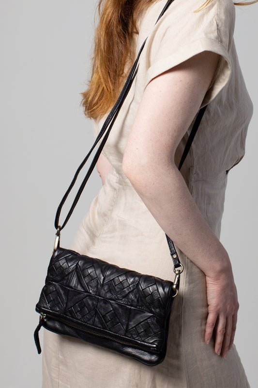 This Black Leather Envelope Clutch takes the classic folded clutch design to the next level with a modern twist.
The Edy Folded Clutch design offers a modern twist, while the spacious interior provides ample room for your essentials. Whether you’re dressing up for a night out or looking for a unique gift, this drop chain clutch is an essential addition to your collection.