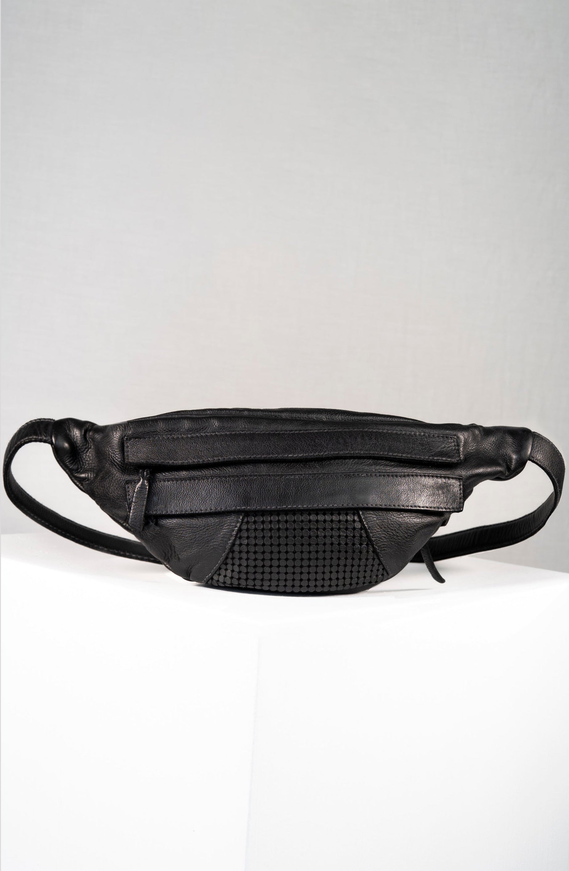 Black leather waist bag on a light gray background